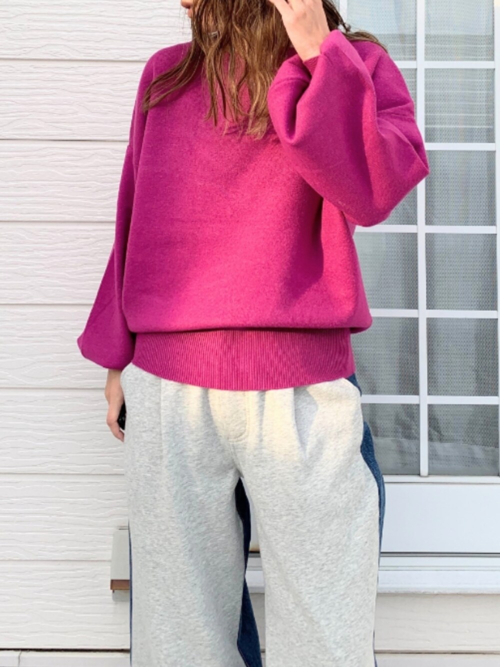 グレー系のデニムパンツ、シルバー系のスニーカー、ピンク系のニット/セーターを着用したレディースの冬コーディネートの3枚目の写真