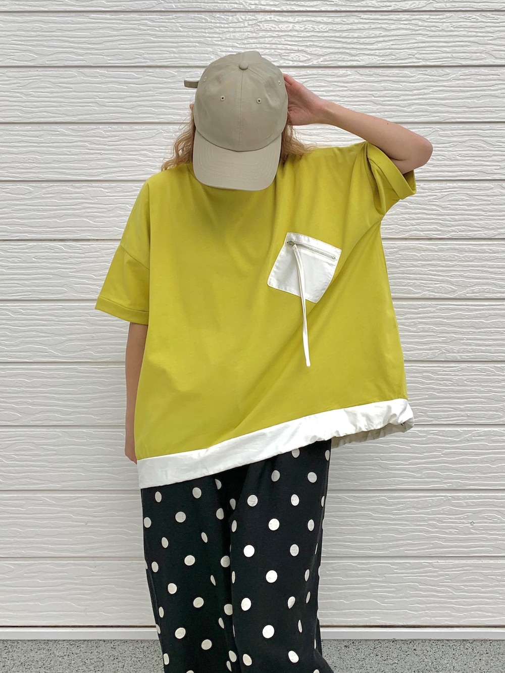 ブラック系のその他パンツ、グリーン系のTシャツ/カットソー、ベージュ系のキャップを着用したレディースの夏コーディネートの4枚目の写真