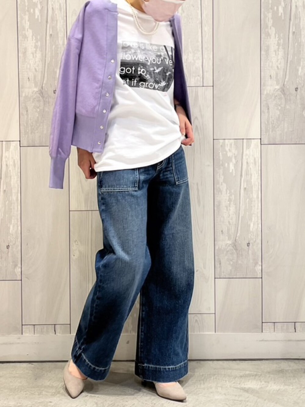 ブルー系のデニムパンツ、オレンジ系のハンドバッグ、ホワイト系のTシャツ/カットソーを着用したレディースの春コーディネートの2枚目の写真