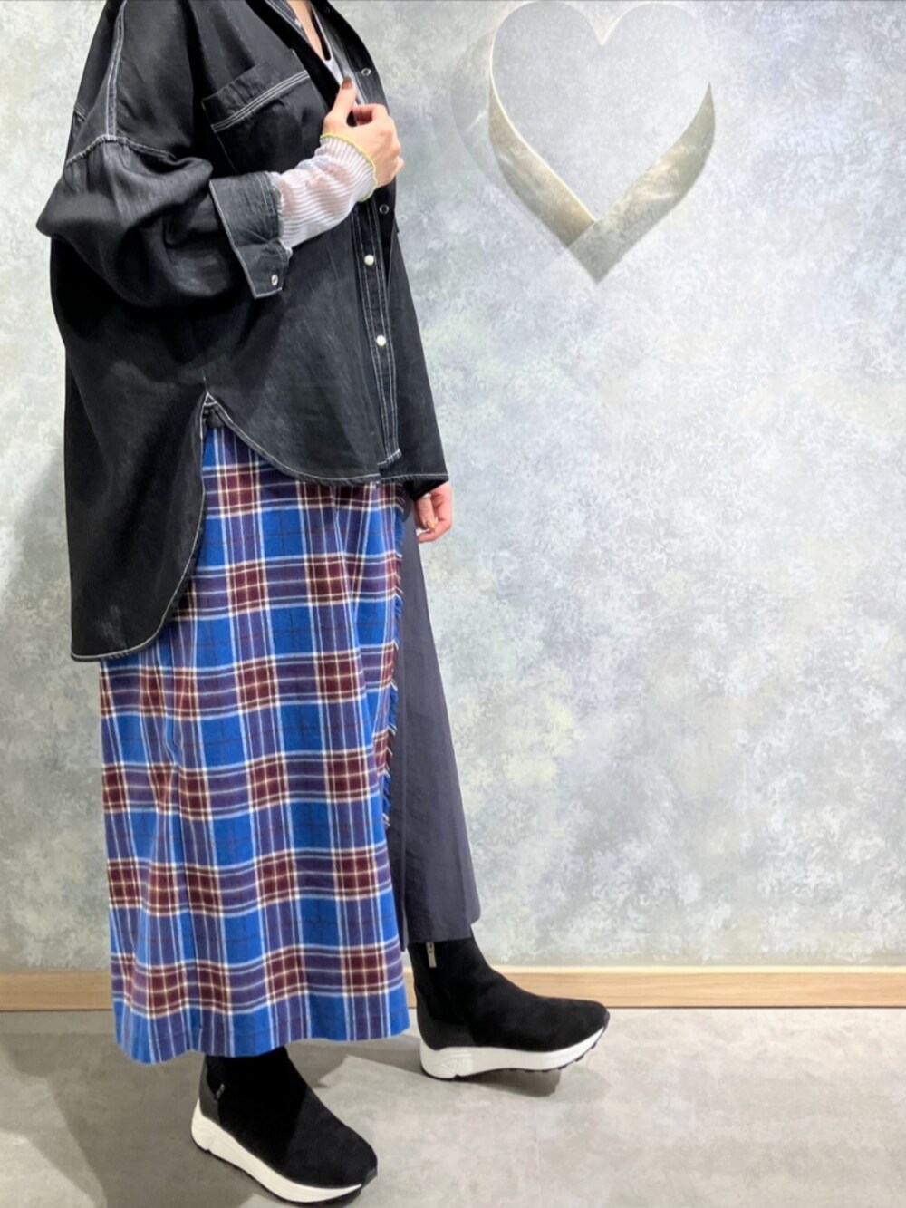 グレー系のブーツ、ブルー系のスカート、グレー系のTシャツ/カットソーを着用したレディースの秋コーディネートの3枚目の写真