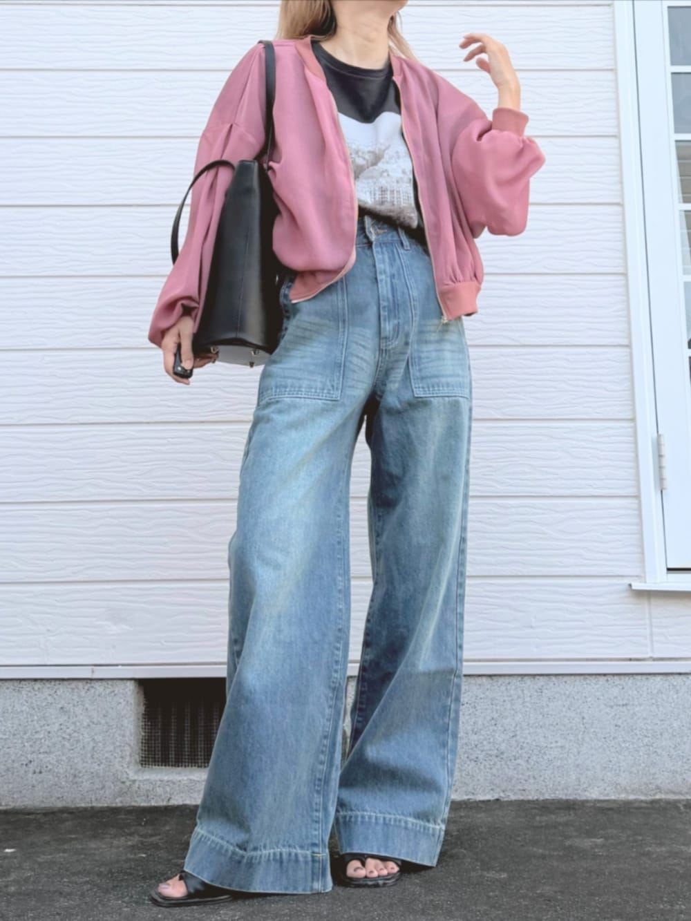 ブラック系のトートバッグ、グレー系のTシャツ/カットソー、ブルー系のデニムパンツを着用したレディースの秋コーディネートの2枚目の写真