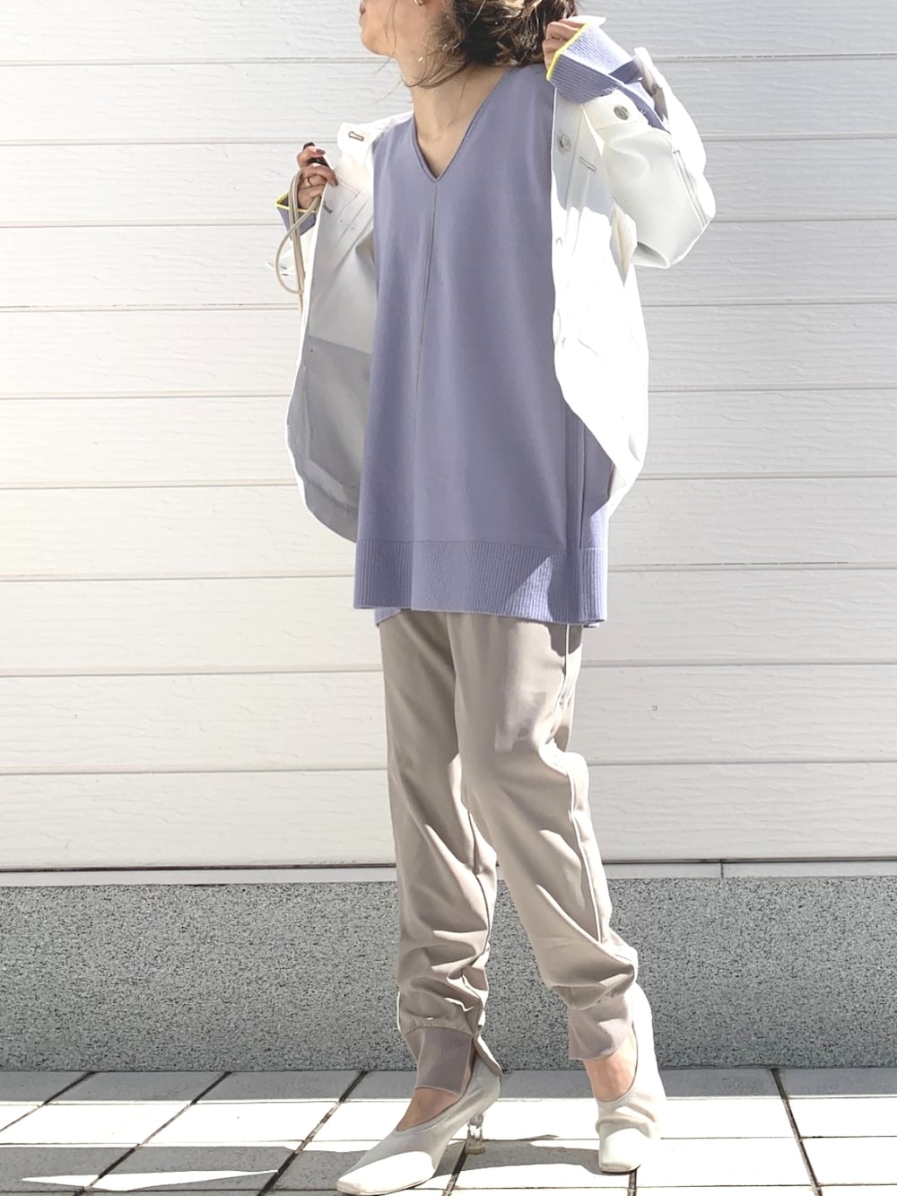 ホワイト系のデニムジャケット、パープル系のニット/セーター、ホワイト系のショルダーバッグを着用したレディースの冬コーディネートの2枚目の写真