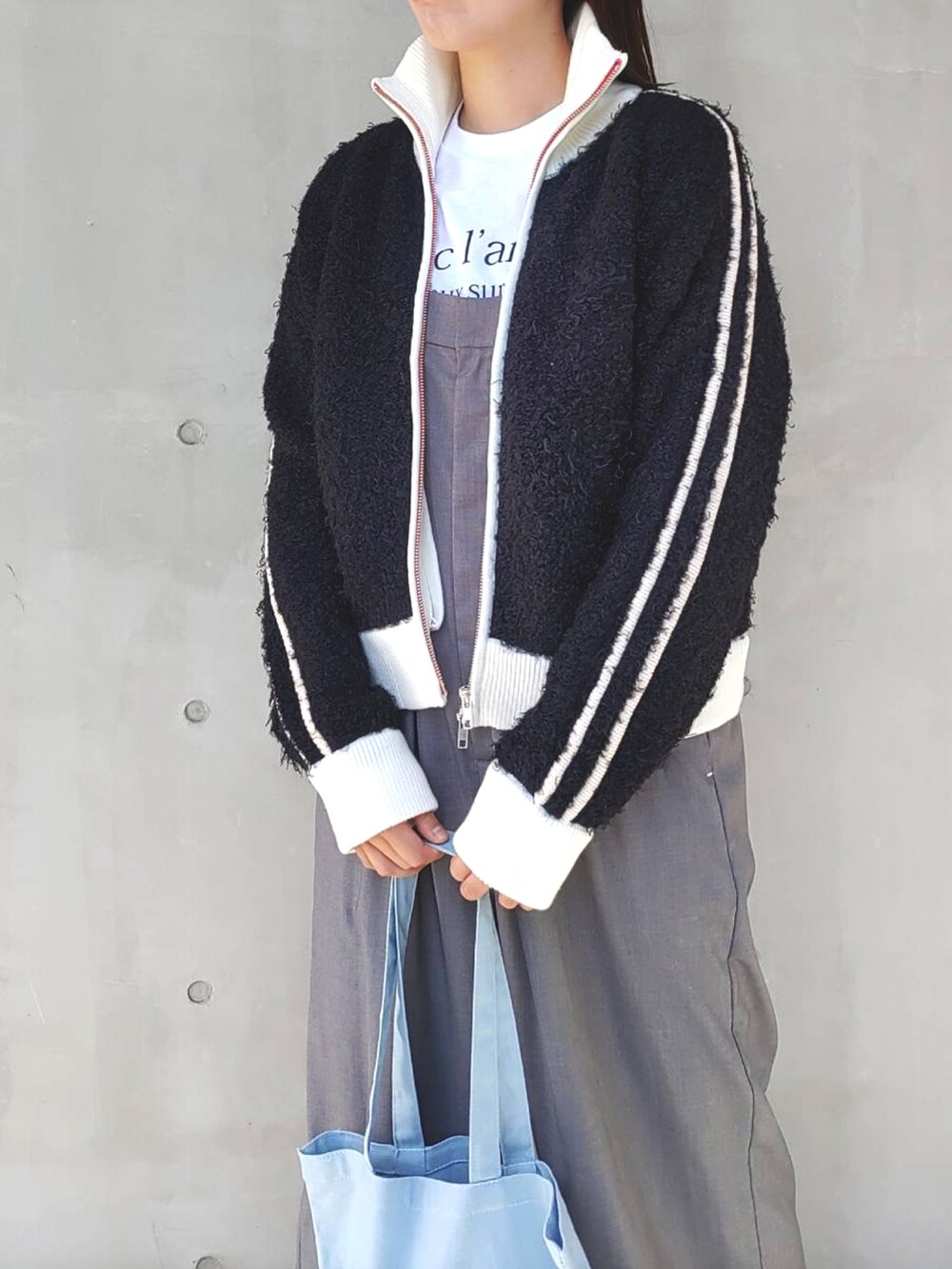 ブラック系のカーディガン/ボレロ、ブルー系のサロペット/オーバーオール、ブルー系のトートバッグを着用したレディースの秋コーディネートの4枚目の写真