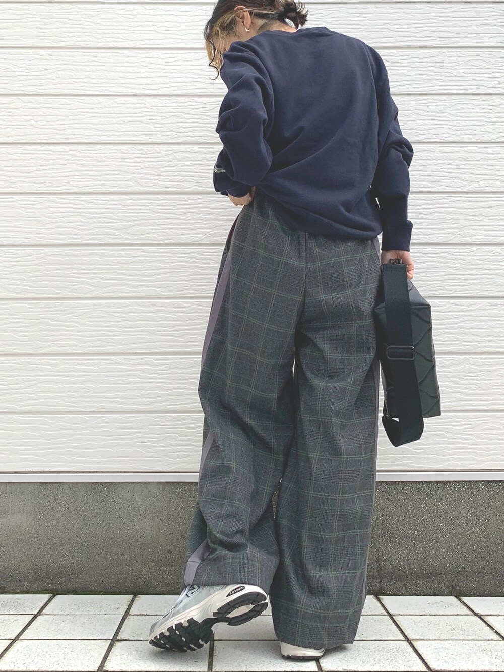 ブラック系のクラッチバッグ、シルバー系のスニーカー、ブルー系のスウェットを着用したレディースの秋コーディネートの3枚目の写真