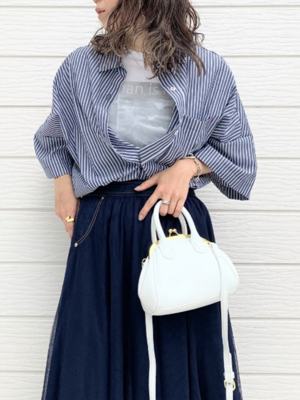 ブルー系のスカート、ホワイト系のショルダーバッグ、ブルー系のシャツ/ブラウスを着用したレディースの春コーディネートの4枚目の写真