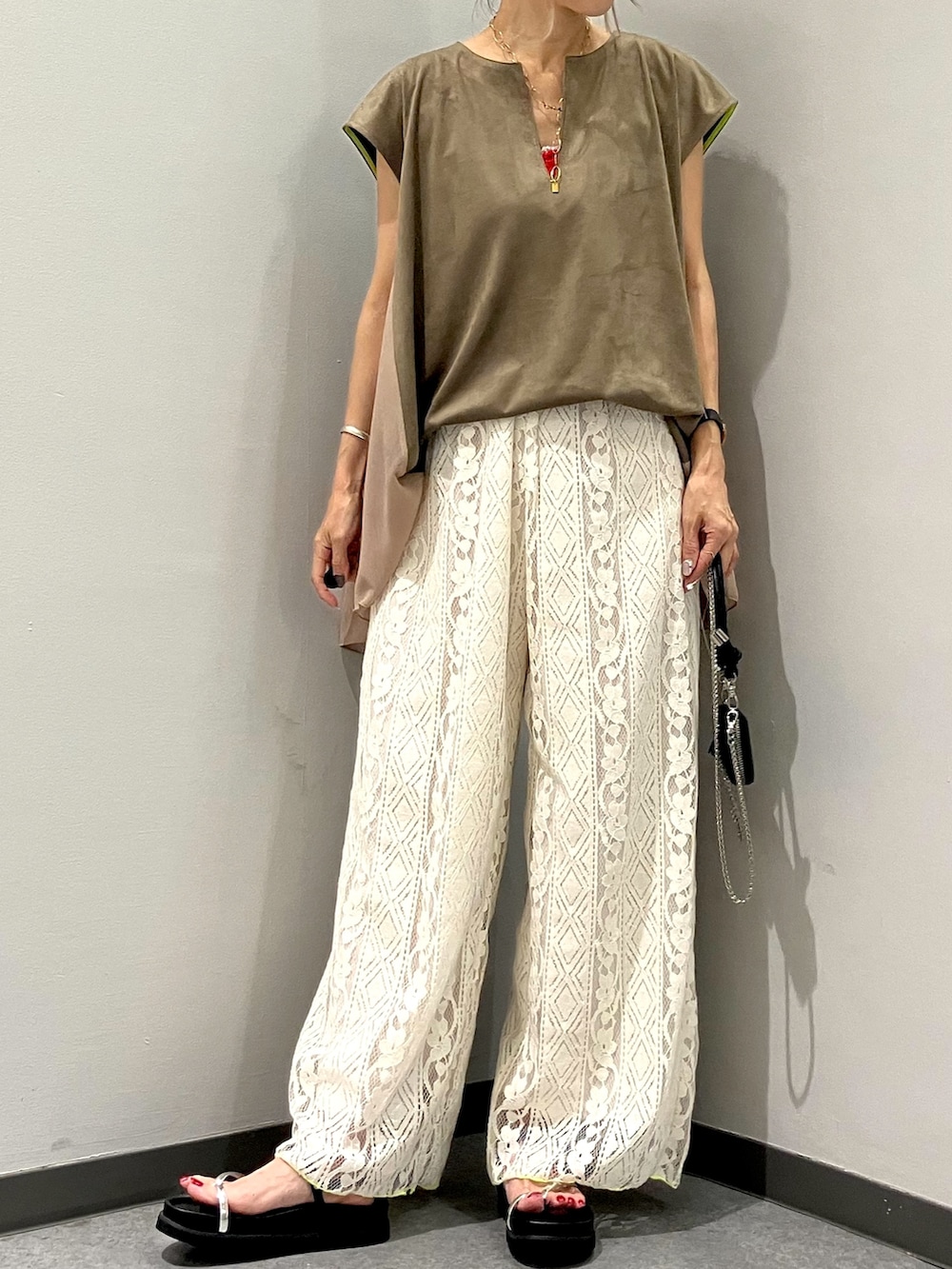 ホワイト系のその他パンツ、グリーン系のTシャツ/カットソー、ブラック系のショルダーバッグを着用したレディースの夏コーディネートの2枚目の写真
