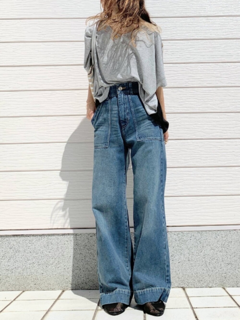 グレー系のTシャツ/カットソー、シルバー系のトートバッグ、ブラック系のパンプスを着用したレディースの春コーディネートの2枚目の写真