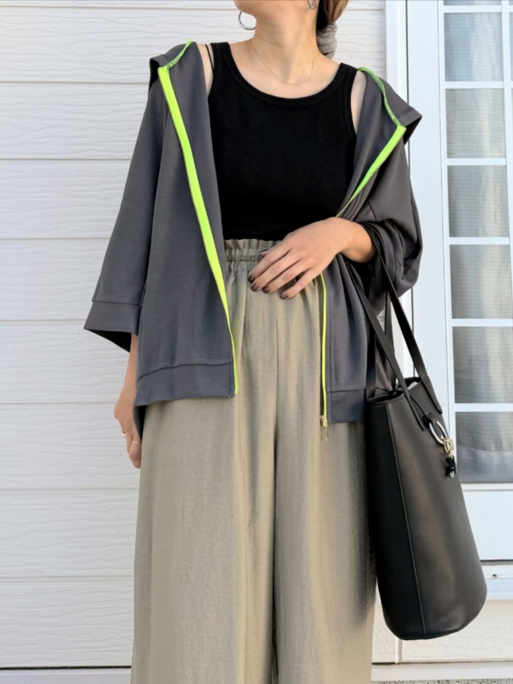 ブラック系のトートバッグ、ブラック系のタンクトップ、グリーン系のその他パンツを着用したレディースの夏コーディネートの4枚目の写真