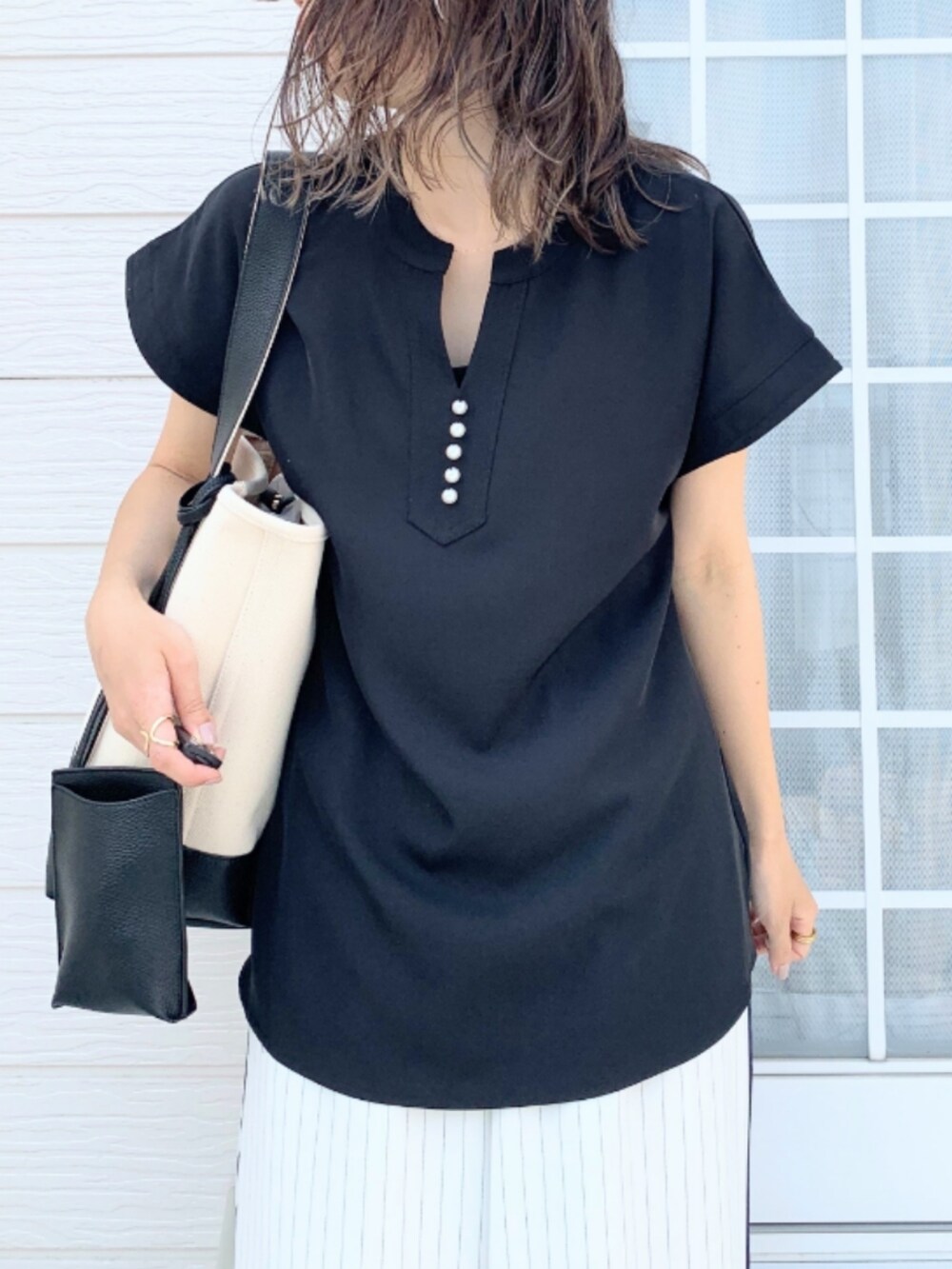 ホワイト系のその他パンツ、ブラック系のシャツ/ブラウス、ブラック系のハンドバッグを着用したレディースの春コーディネートの4枚目の写真