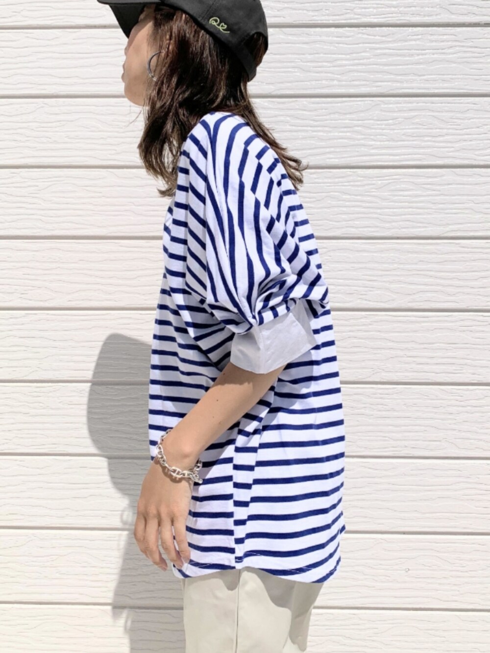 ホワイト系のその他パンツ、ブルー系のTシャツ/カットソー、ブラック系のショルダーバッグを着用したレディースの春コーディネートの4枚目の写真