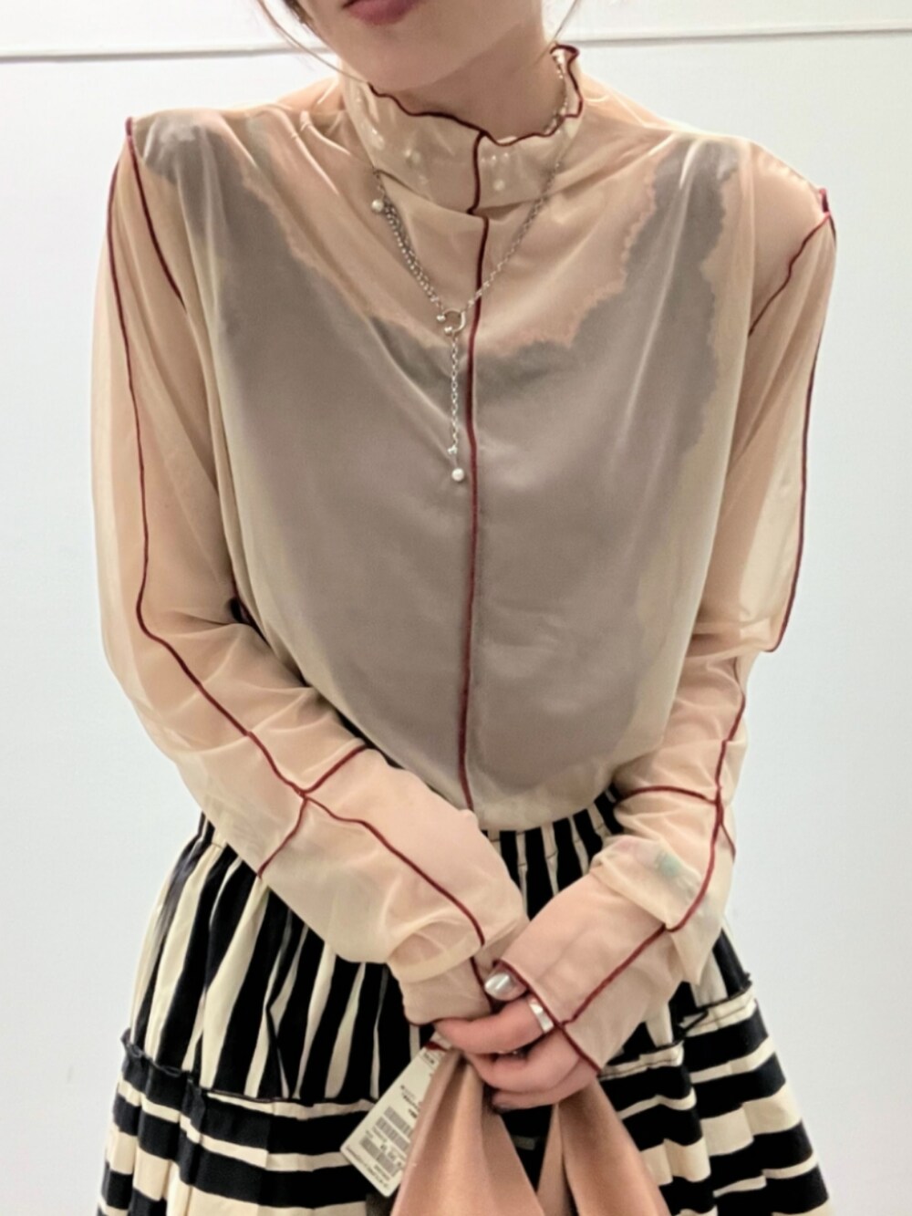 ベージュ系のトートバッグ、ブラック系のスカート、ベージュ系のTシャツ/カットソーを着用したレディースの夏コーディネートの4枚目の写真