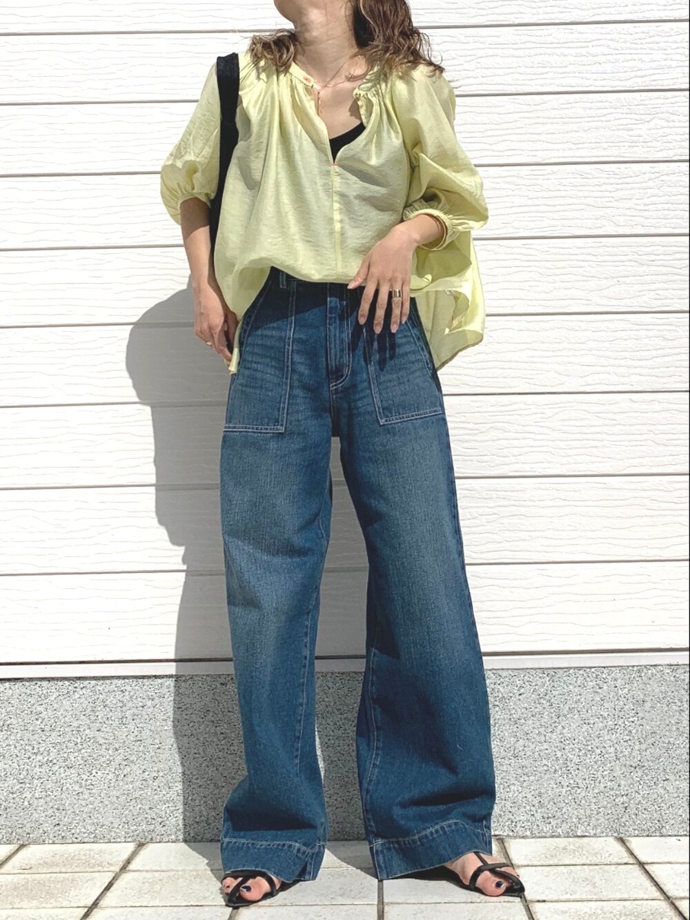 ブルー系のデニムパンツ、ブラック系のショルダーバッグ、グリーン系のシャツ/ブラウスを着用したレディースの春コーディネートの2枚目の写真