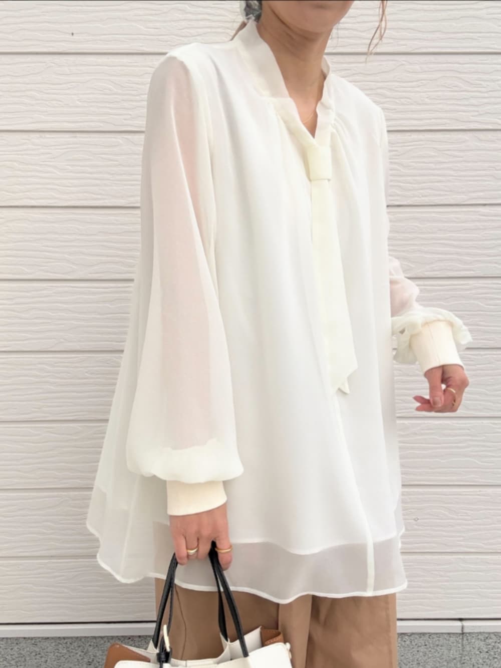 ベージュ系のその他パンツ、ホワイト系のシャツ/ブラウス、ホワイト系のトートバッグを着用したレディースの冬コーディネートの4枚目の写真