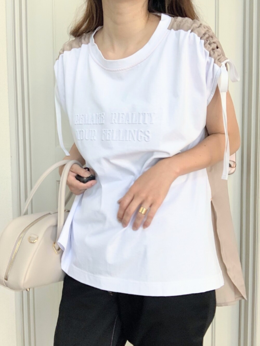 ブラック系のその他パンツ、イエロー系のサンダル、ホワイト系のボストンバッグを着用したレディースの夏コーディネートの3枚目の写真