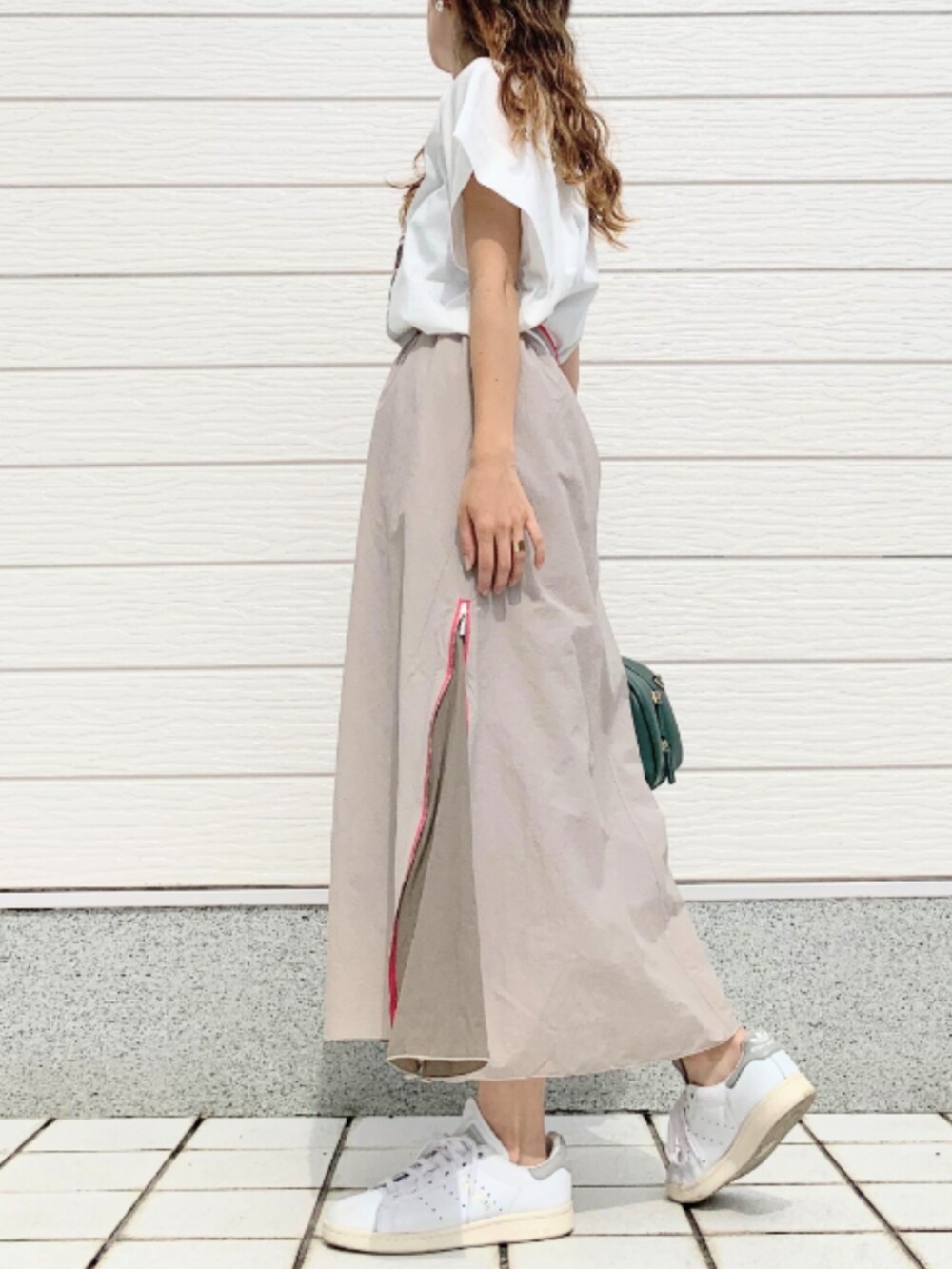 ホワイト系のスニーカー、ホワイト系のTシャツ/カットソー、ベージュ系のスカートを着用したレディースの夏コーディネートの4枚目の写真