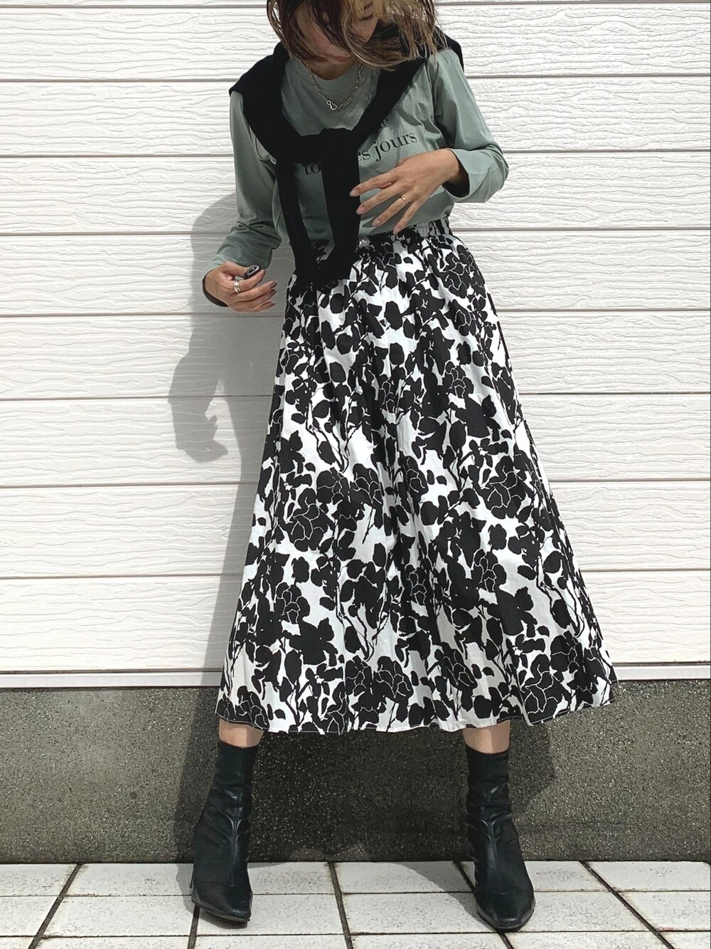 ブラック系のスカート、グリーン系のTシャツ/カットソーを着用したレディースの秋コーディネートの2枚目の写真