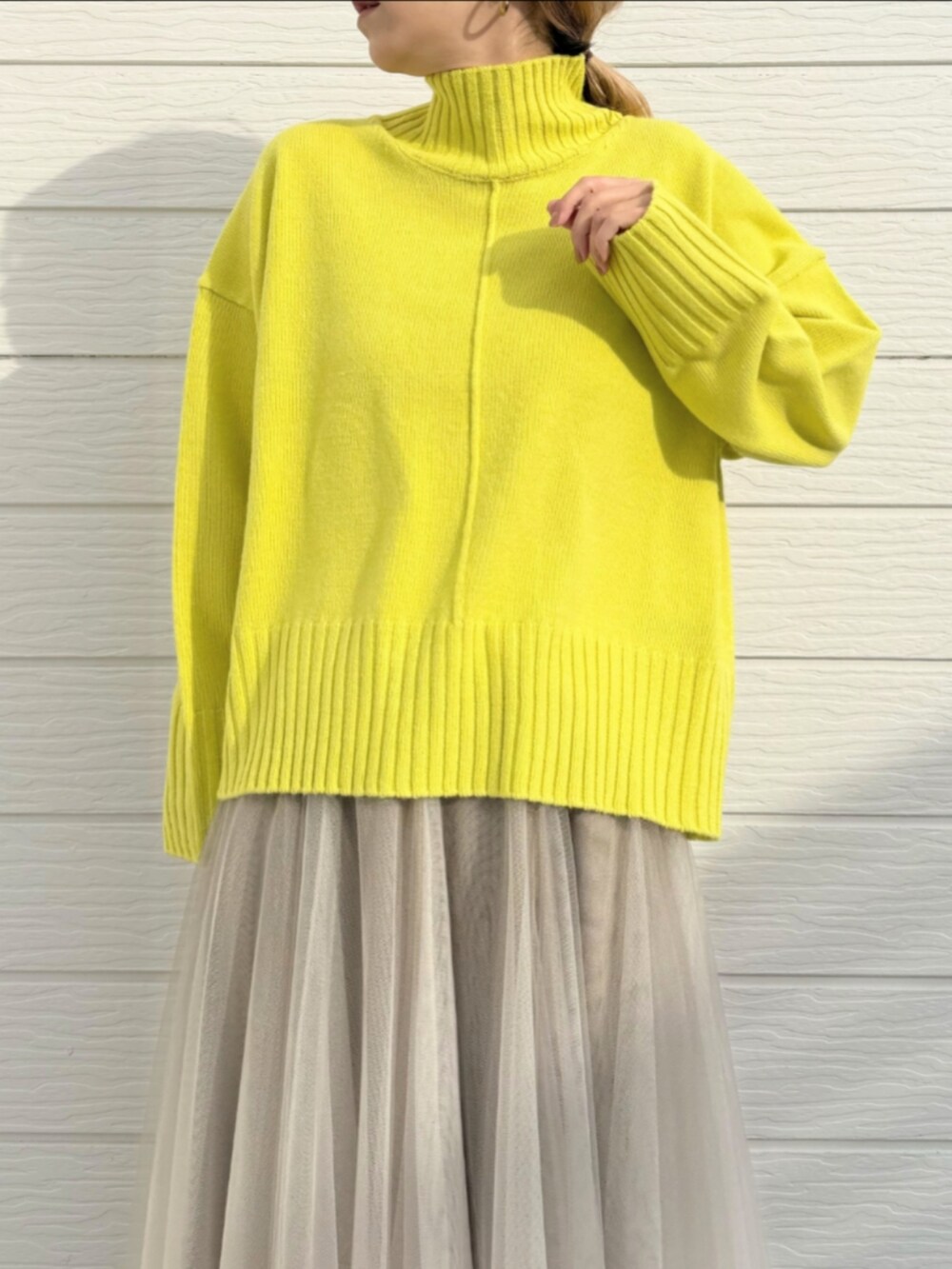 ゴールド系のスカート、グリーン系のニット/セーターを着用したレディースの冬コーディネートの4枚目の写真