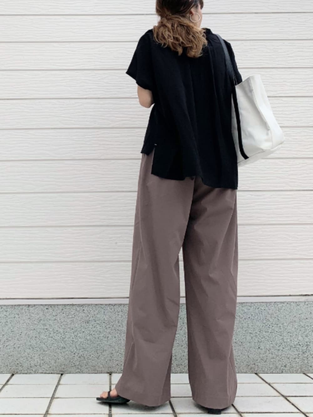 ホワイト系のトートバッグ、ブラウン系のその他パンツ、ブラック系のシャツ/ブラウスを着用したレディースの夏コーディネートの3枚目の写真