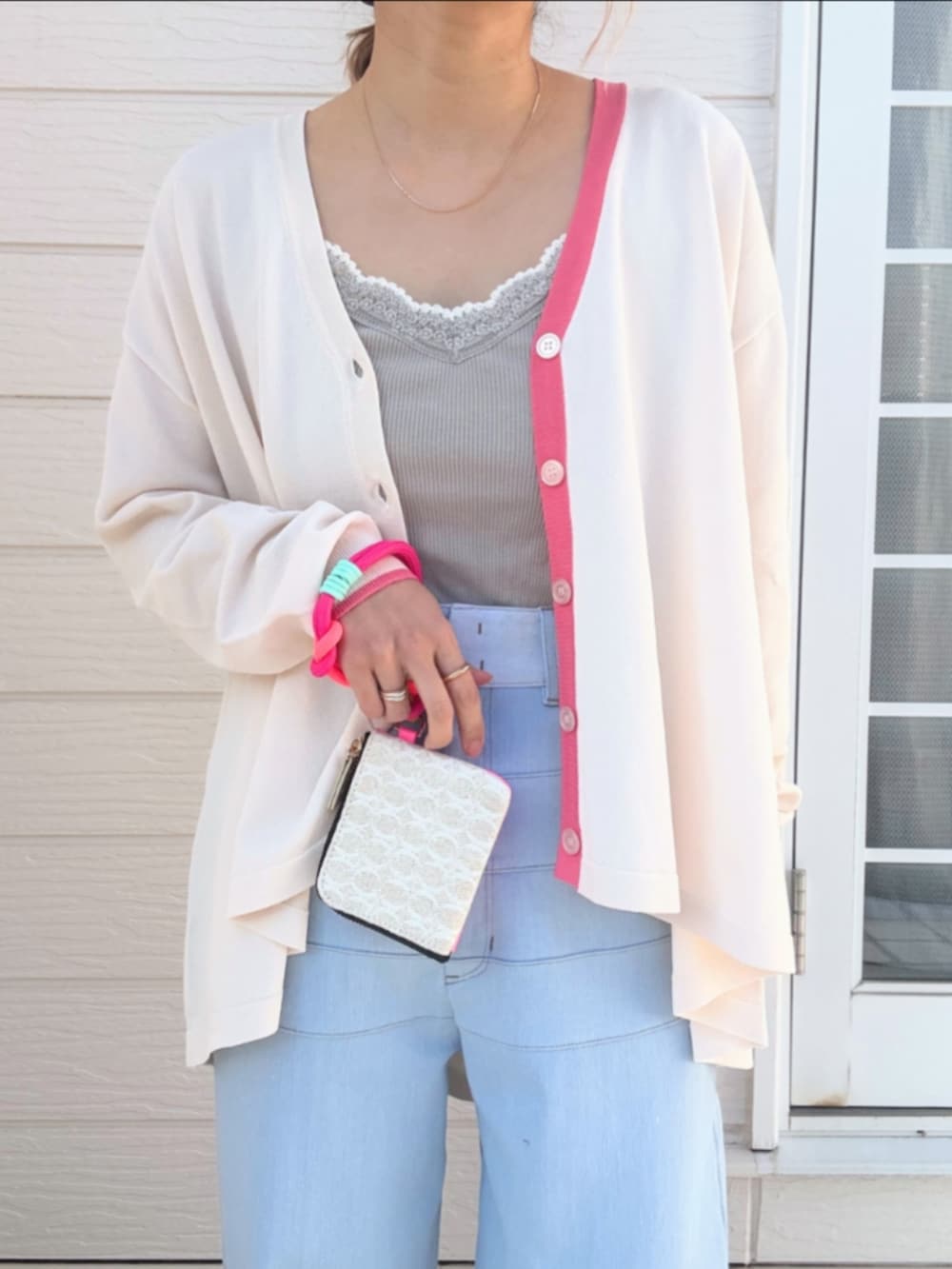 ブルー系のデニムパンツ、グレー系のタンクトップ、ベージュ系のカーディガン/ボレロを着用したレディースの冬コーディネートの4枚目の写真