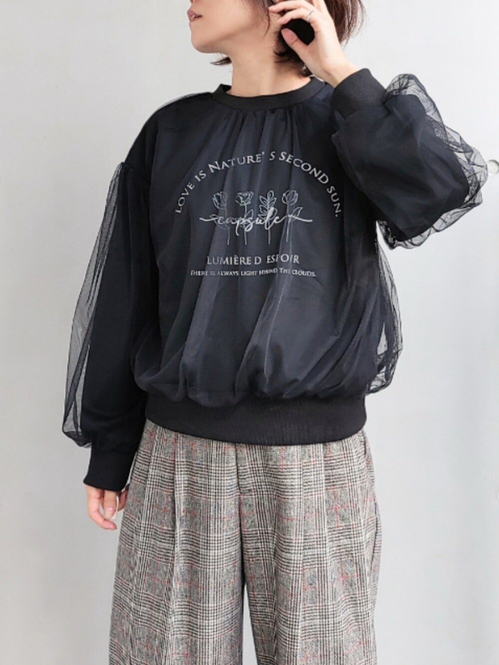 ブラック系のスラックス、ブラック系のスウェット、ホワイト系のボストンバッグを着用したレディースの秋コーディネートの4枚目の写真