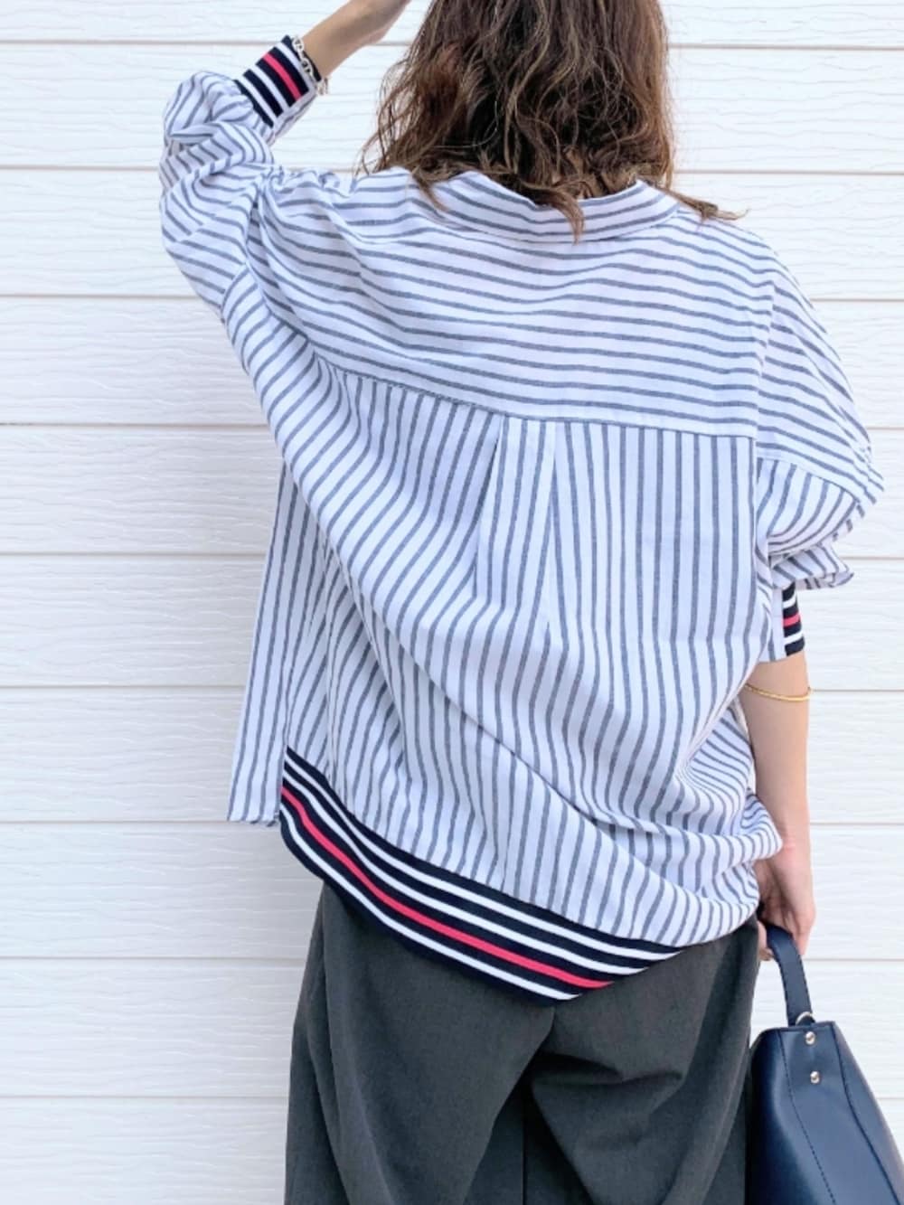 ブルー系のハンドバッグ、ブルー系のシャツ/ブラウス、ブラック系のキャミソールを着用したレディースの夏コーディネートの4枚目の写真