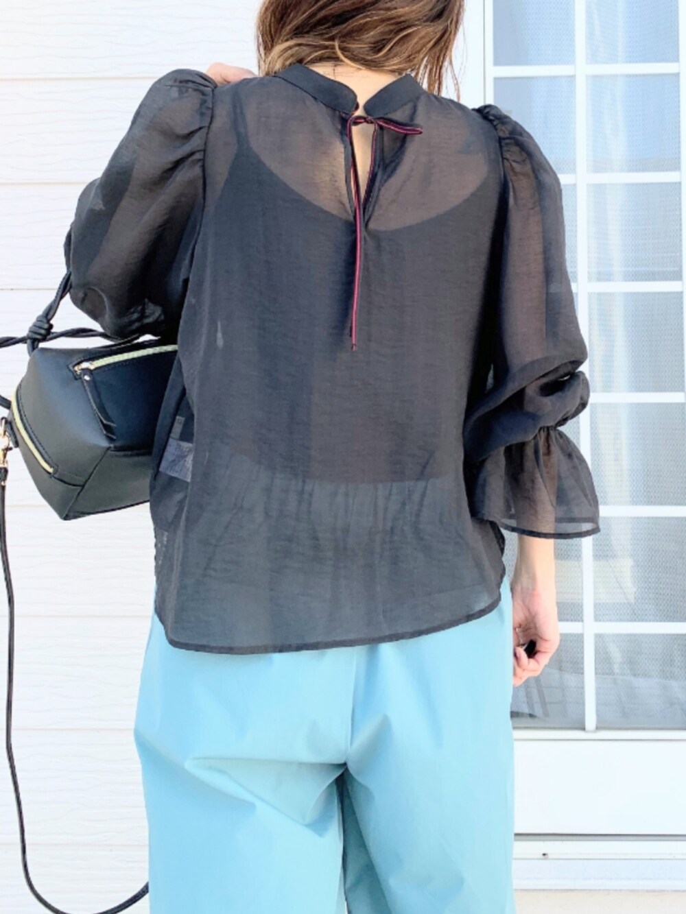 ブラック系のハンドバッグ、ブルー系のその他パンツ、ブラック系のシャツ/ブラウスを着用したレディースの春コーディネートの5枚目の写真