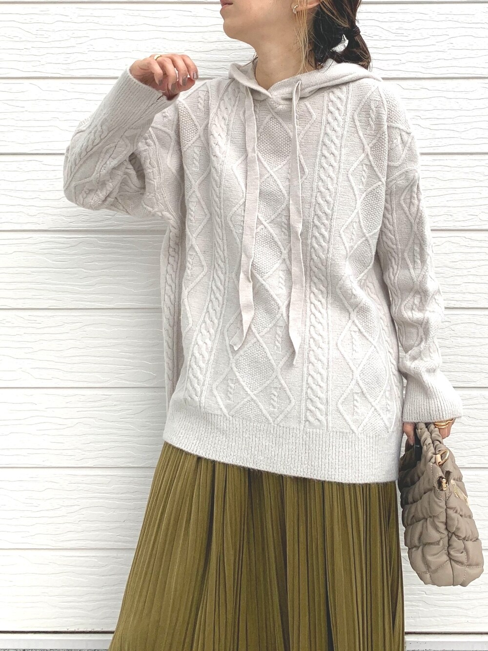 ブラック系のブーツ、ベージュ系のショルダーバッグ、ホワイト系のニット/セーターを着用したレディースの冬コーディネートの4枚目の写真