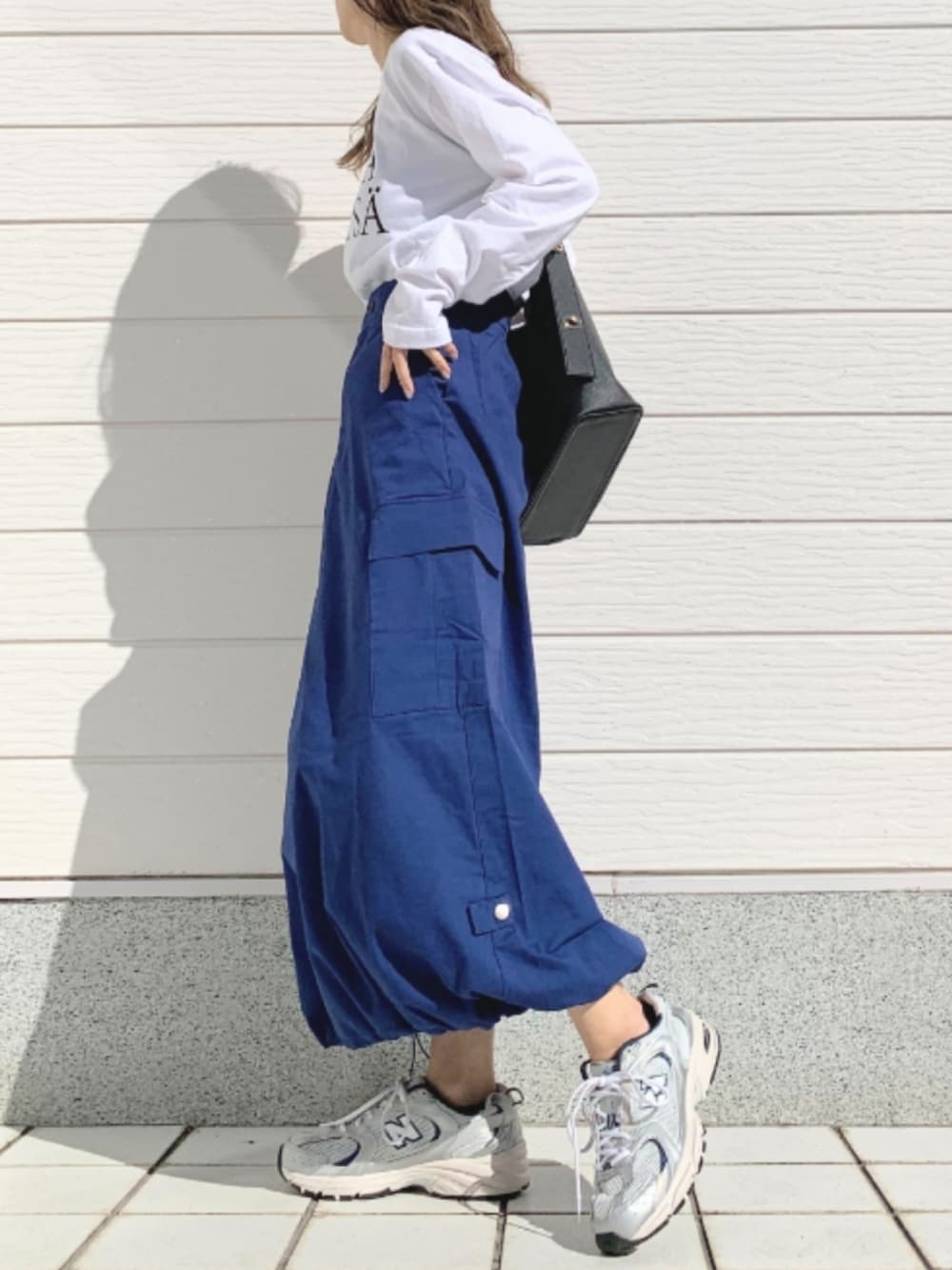 ホワイト系のTシャツ/カットソー、シルバー系のスニーカー、ブルー系のスカートを着用したレディースの春コーディネートの2枚目の写真