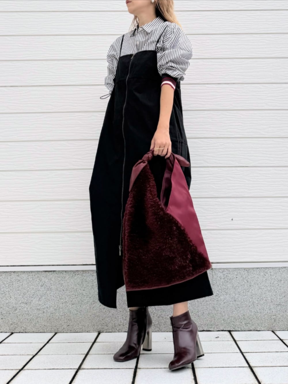 ブラウン系のブーツ、ブラック系のジャンパースカート、ブラック系のシャツ/ブラウスを着用したレディースの秋コーディネートの2枚目の写真