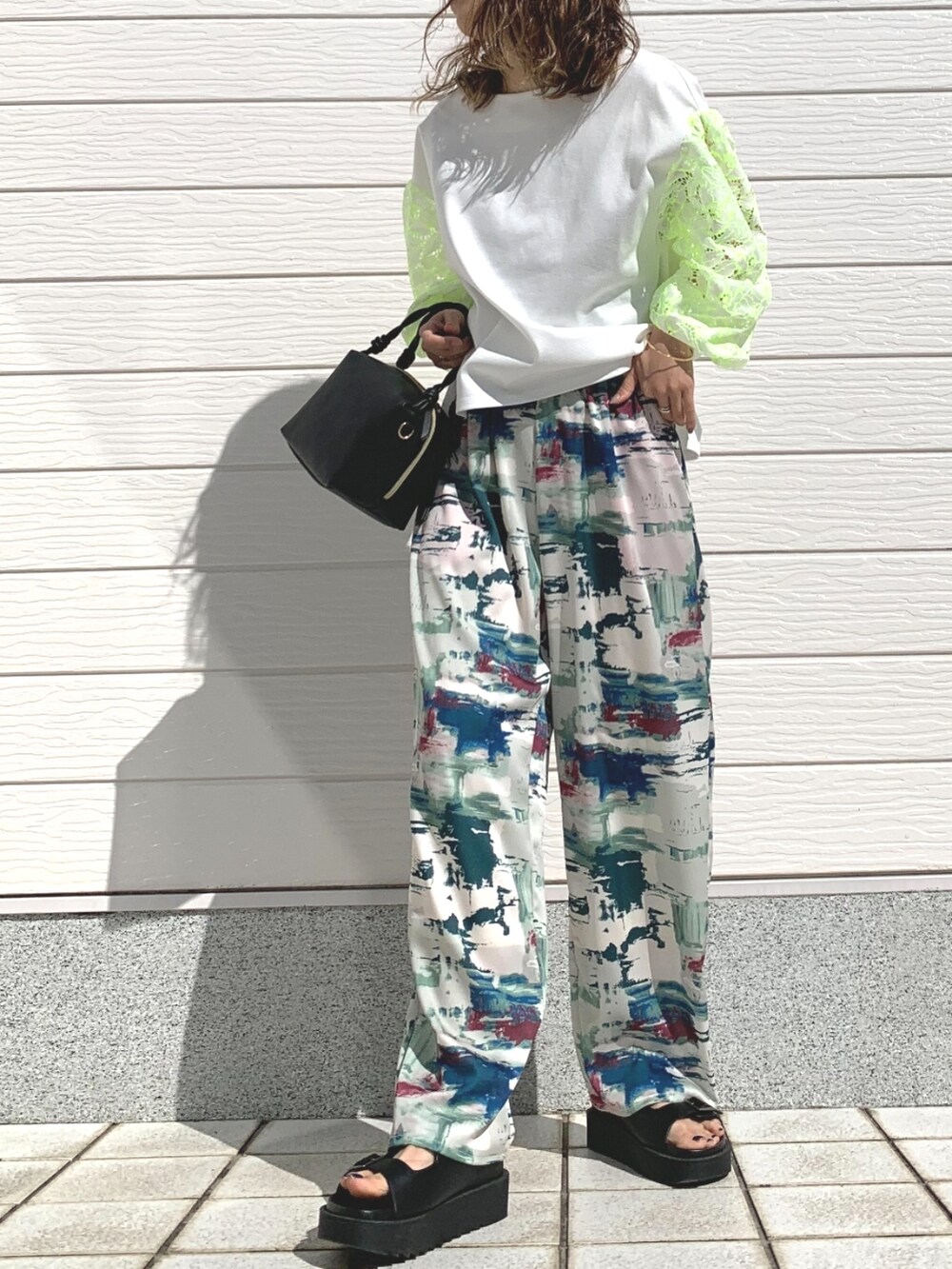 グリーン系のその他パンツ、ブラック系のサンダル、ホワイト系のTシャツ/カットソーを着用したレディースの春コーディネートの2枚目の写真