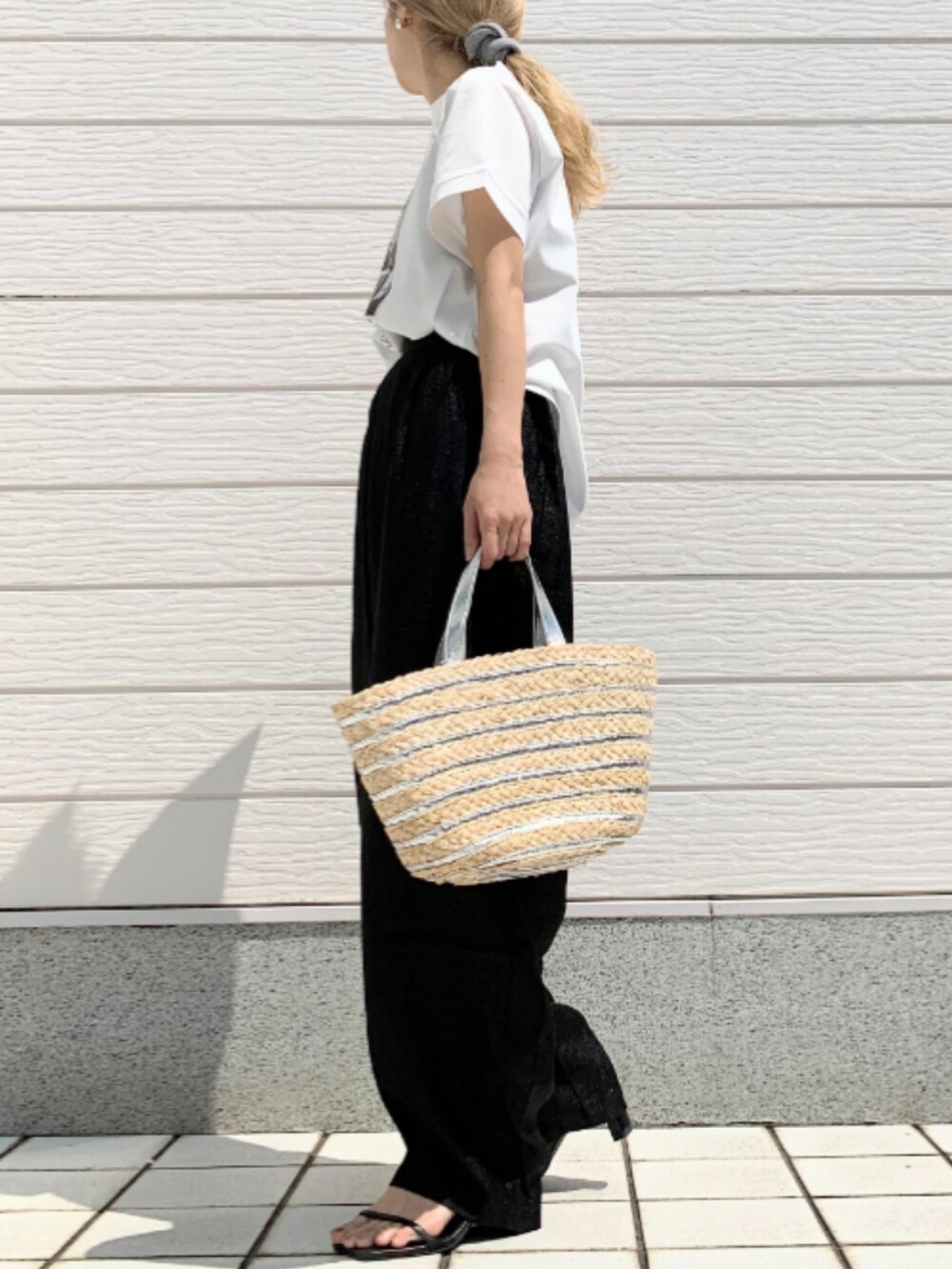 シルバー系のかごバッグ、ブラック系のその他パンツ、ホワイト系のTシャツ/カットソーを着用したレディースの春コーディネートの2枚目の写真