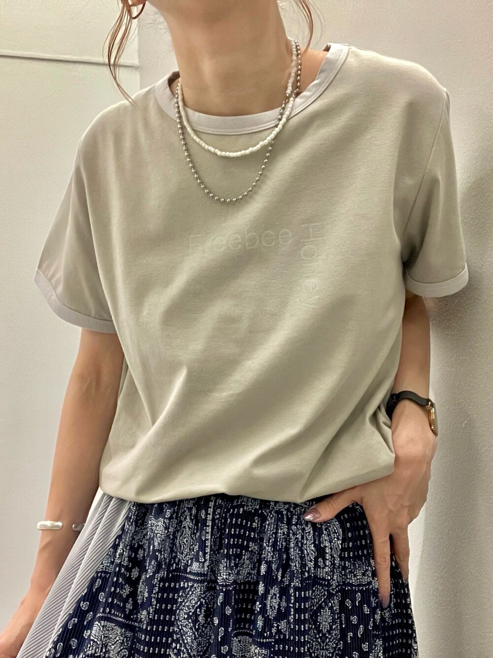 ホワイト系のトートバッグ、ブルー系のスカート、グリーン系のTシャツ/カットソーを着用したレディースの夏コーディネートの2枚目の写真