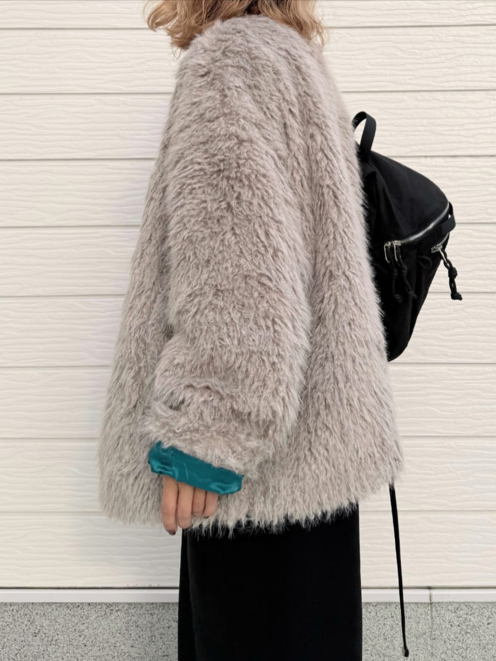 シルバー系のスニーカー、ブラック系のワンピース、ブラック系のバックパック/リュックを着用したレディースの秋コーディネートの5枚目の写真