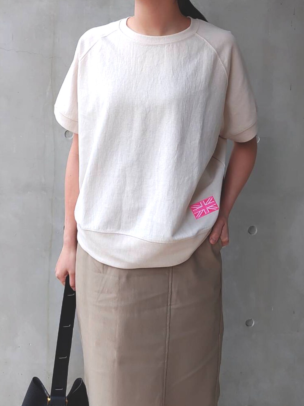 ベージュ系のスウェット、ホワイト系のスニーカー、ベージュ系のスカートを着用したレディースの春コーディネートの4枚目の写真