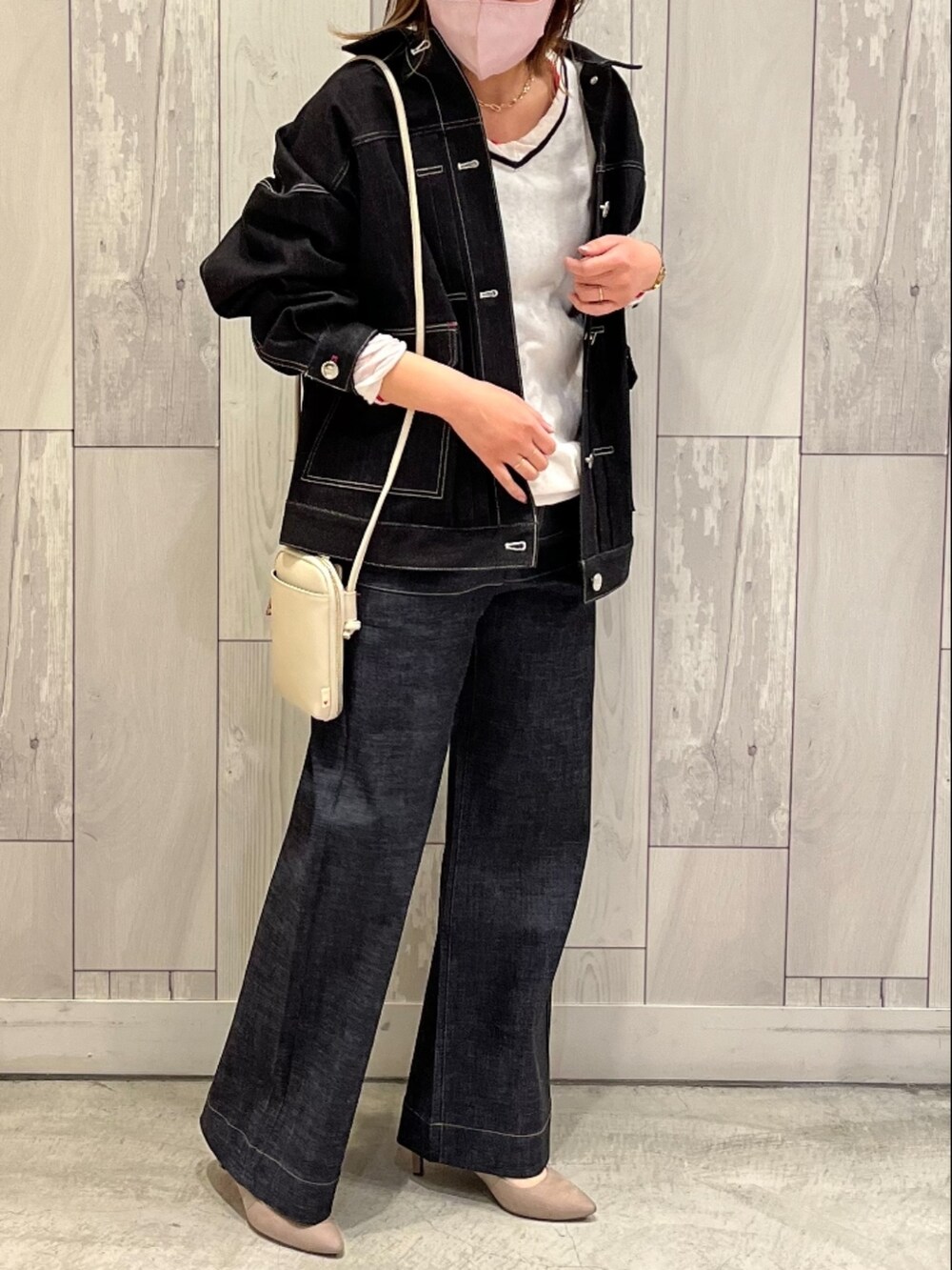 ブルー系のデニムパンツ、ブラック系のデニムジャケット、シルバー系のショルダーバッグを着用したレディースの冬コーディネートの2枚目の写真