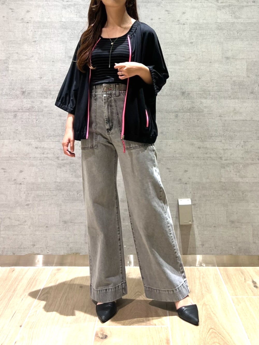 グレー系のデニムパンツ、ブラック系のパーカーを着用したレディースの夏コーディネートの3枚目の写真
