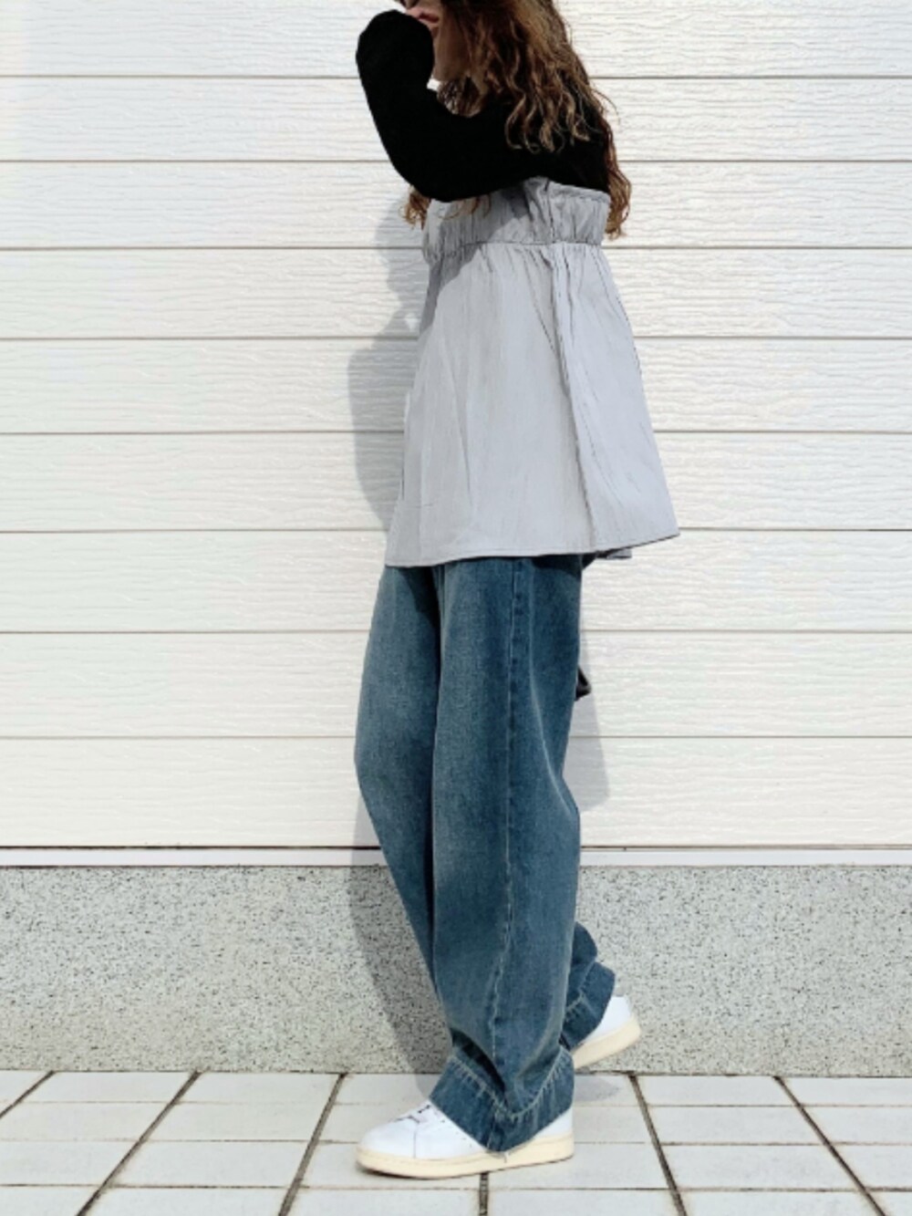 ブルー系のデニムパンツ、ホワイト系のスニーカー、ブラック系のTシャツ/カットソーを着用したレディースの夏コーディネートの2枚目の写真