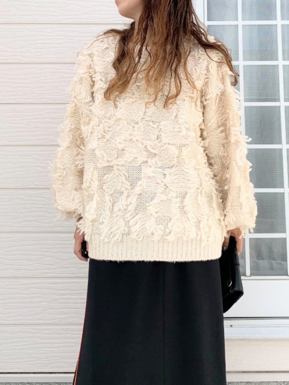 ブラック系のスカート、ホワイト系のニット/セーターを着用したレディースの秋コーディネートの4枚目の写真