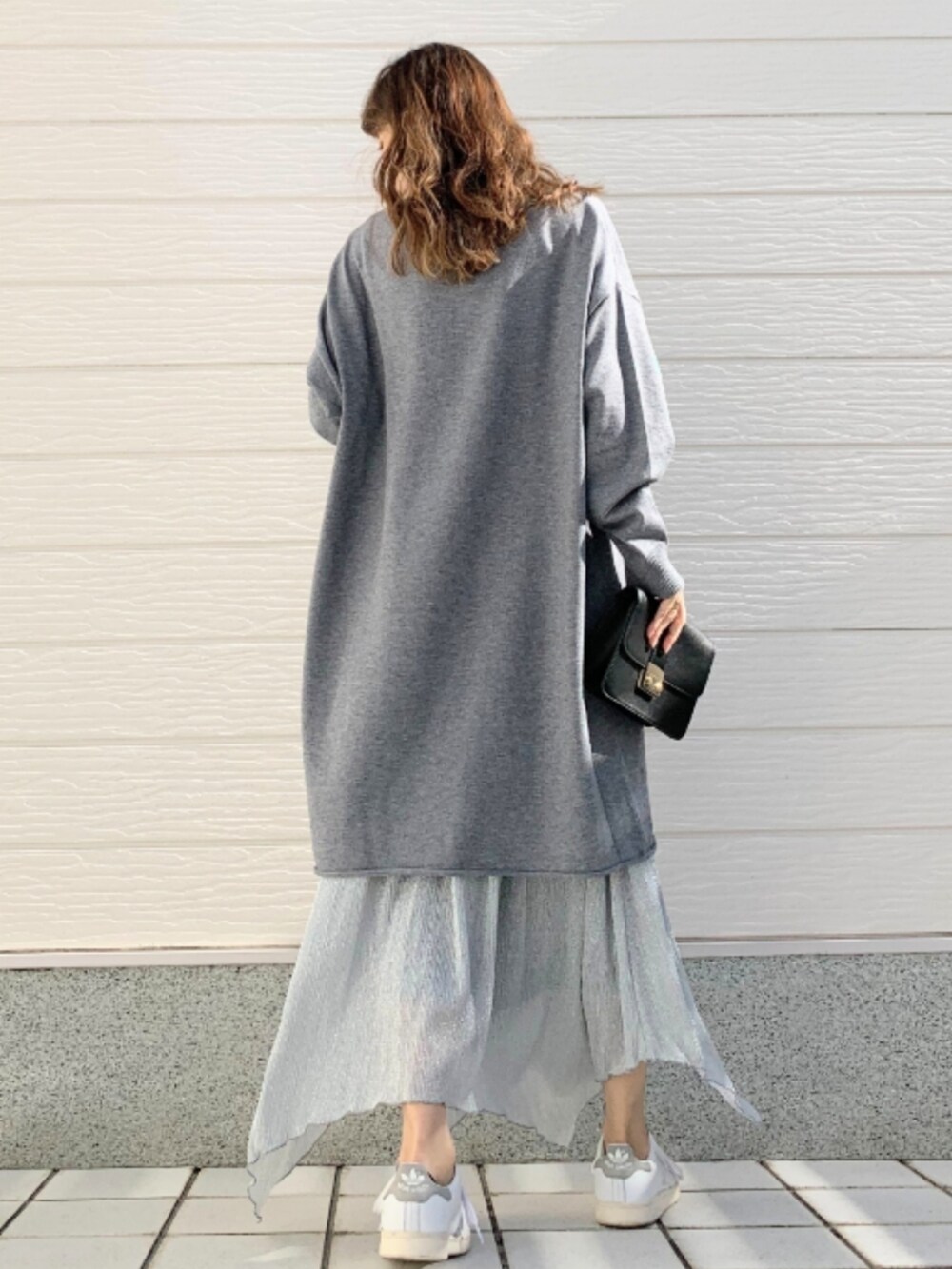 シルバー系のスカート、グレー系のニット/セーターを着用したレディースの冬コーディネートの3枚目の写真