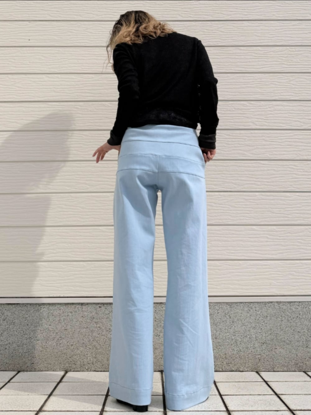 ブルー系のデニムパンツ、ブラック系のサンダル、ブラック系のTシャツ/カットソーを着用したレディースの冬コーディネートの3枚目の写真