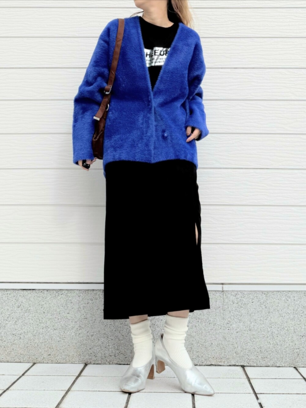 ブラック系のスカート、ブルー系のカーディガン/ボレロ、ブラック系のTシャツ/カットソーを着用したレディースの秋コーディネートの2枚目の写真