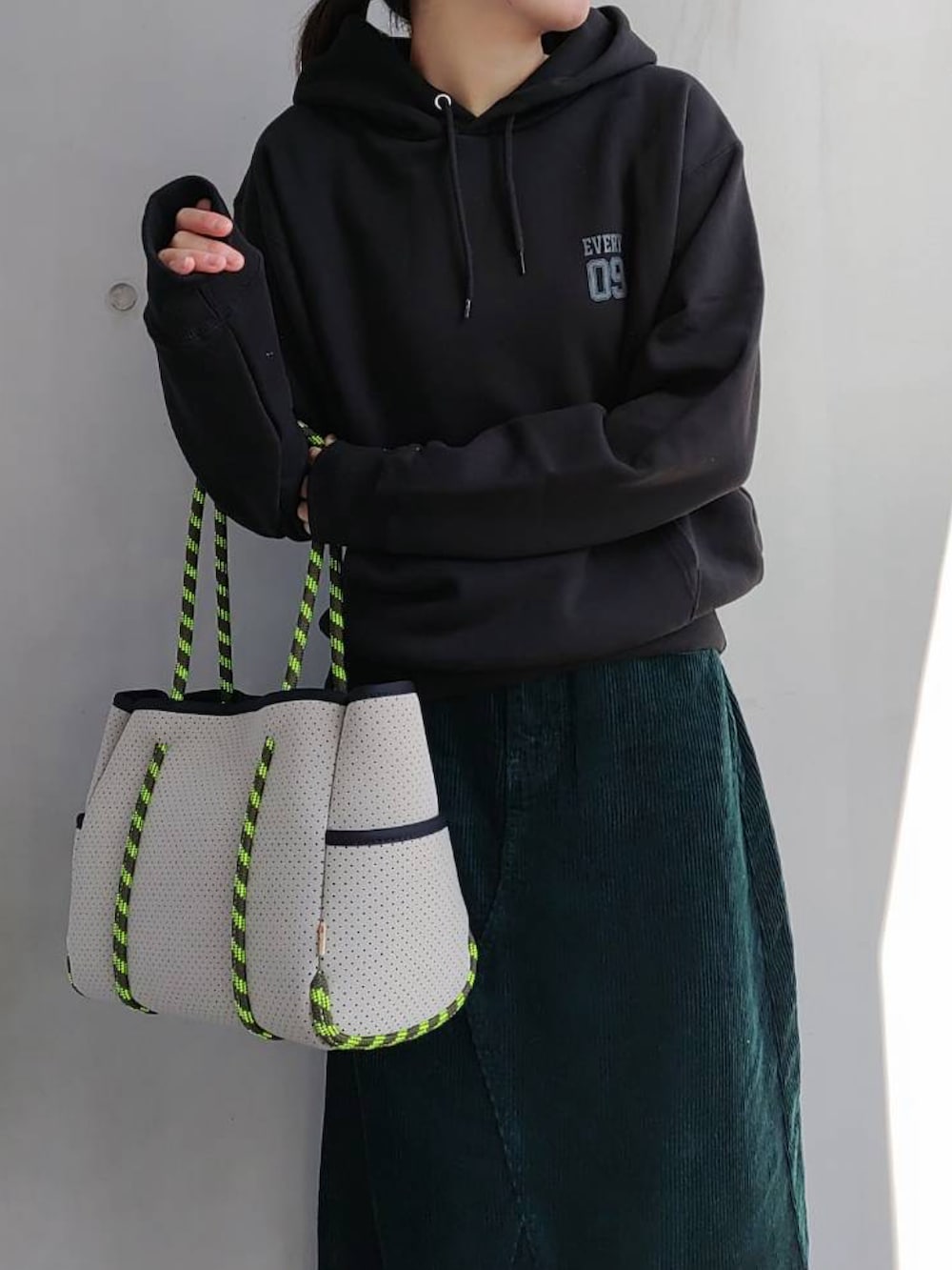 グリーン系のスカート、グレー系のトートバッグ、ブラック系のスニーカーを着用したレディースの冬コーディネートの4枚目の写真