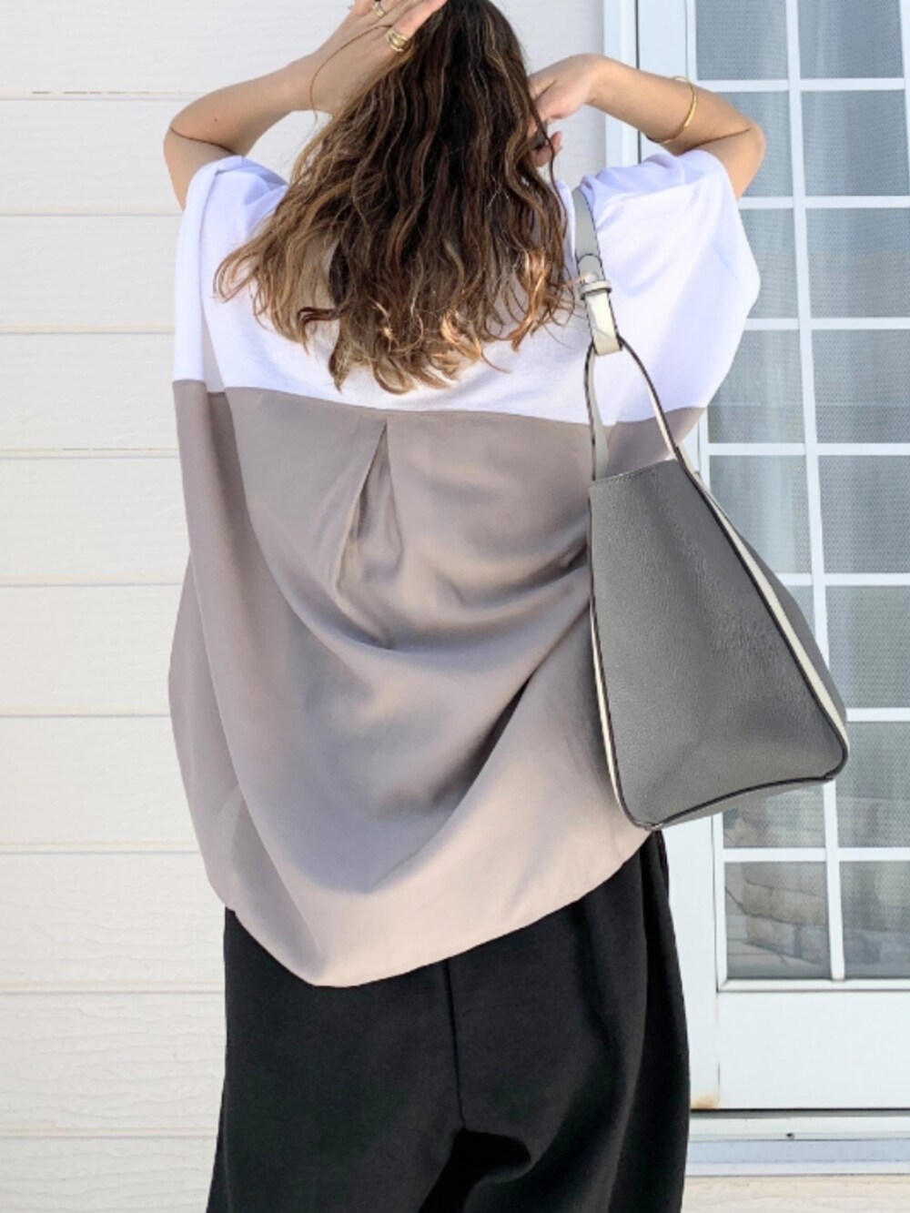 ブラック系のその他パンツ、グレー系のトートバッグ、ホワイト系のTシャツ/カットソーを着用したレディースの春コーディネートの5枚目の写真