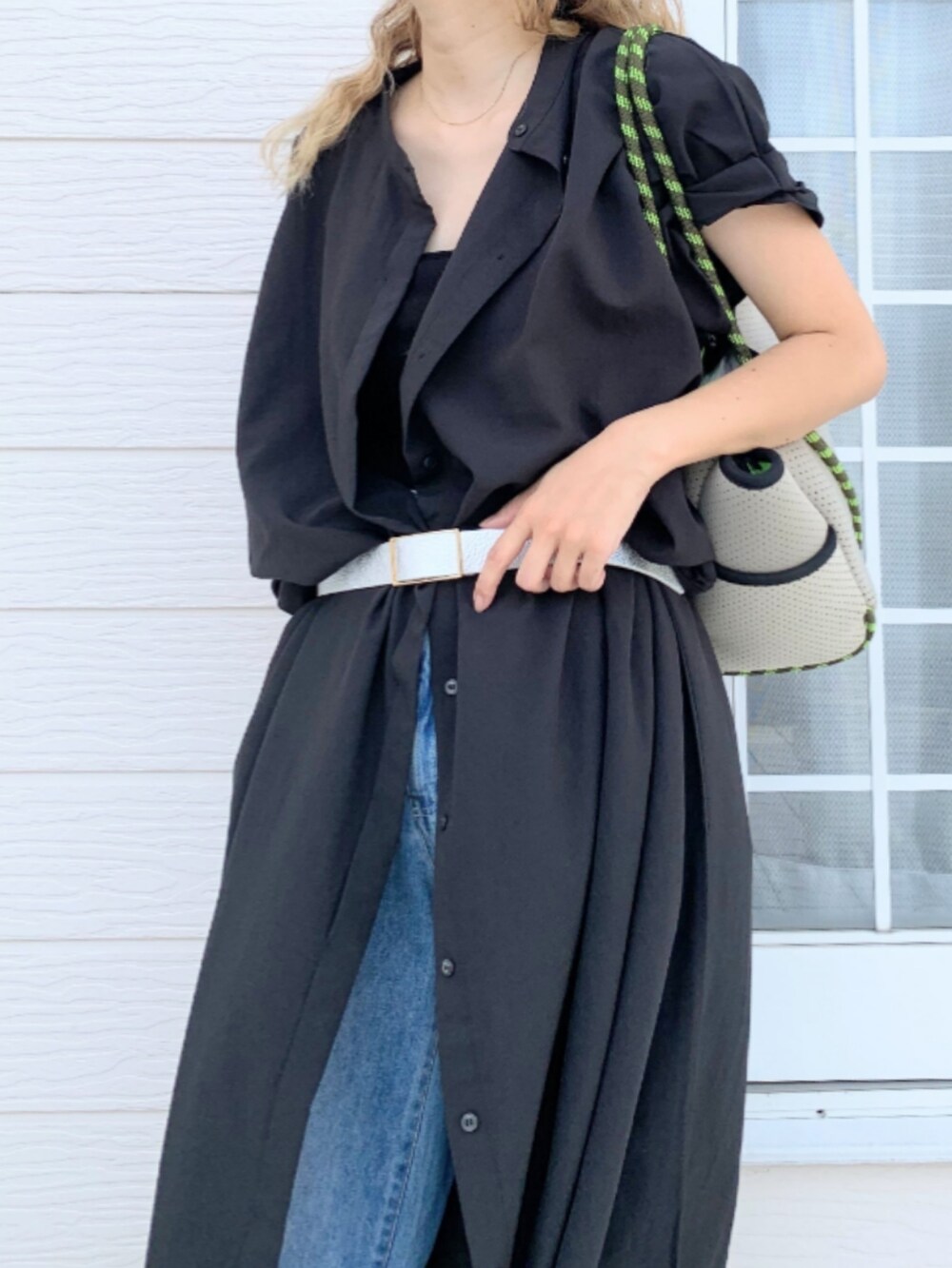 グレー系のトートバッグ、ブルー系のデニムパンツ、ブラック系のシャツワンピースを着用したレディースの夏コーディネートの4枚目の写真