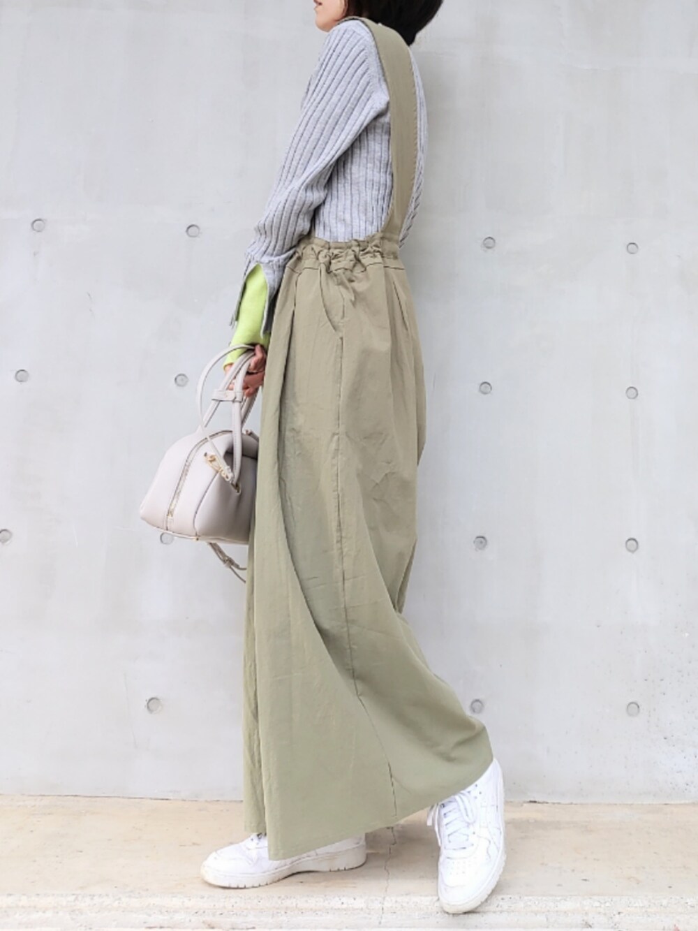 ホワイト系のボストンバッグ、ホワイト系のスニーカー、グレー系のニット/セーターを着用したレディースの冬コーディネートの3枚目の写真