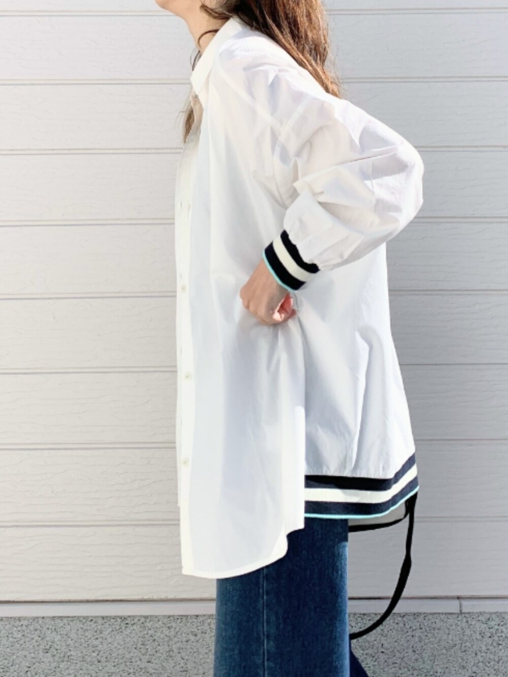 ブルー系のデニムパンツ、ホワイト系のシャツ/ブラウス、ブラック系のキャミソールを着用したレディースの冬コーディネートの3枚目の写真