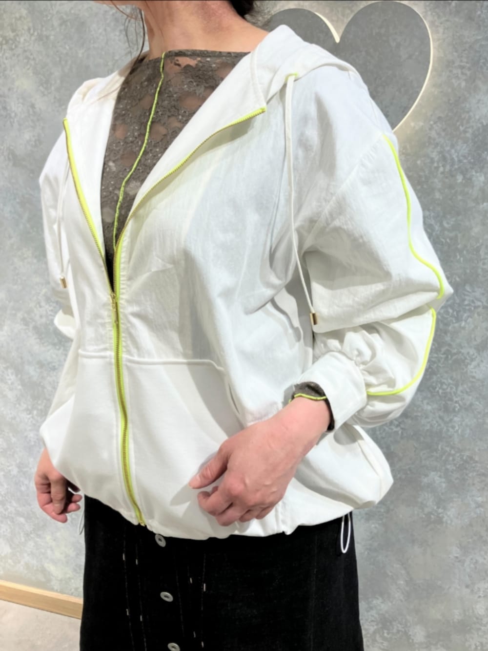 ブルー系のデニムスカート、グリーン系のTシャツ/カットソー、ホワイト系のパーカーを着用したレディースの春コーディネートの4枚目の写真