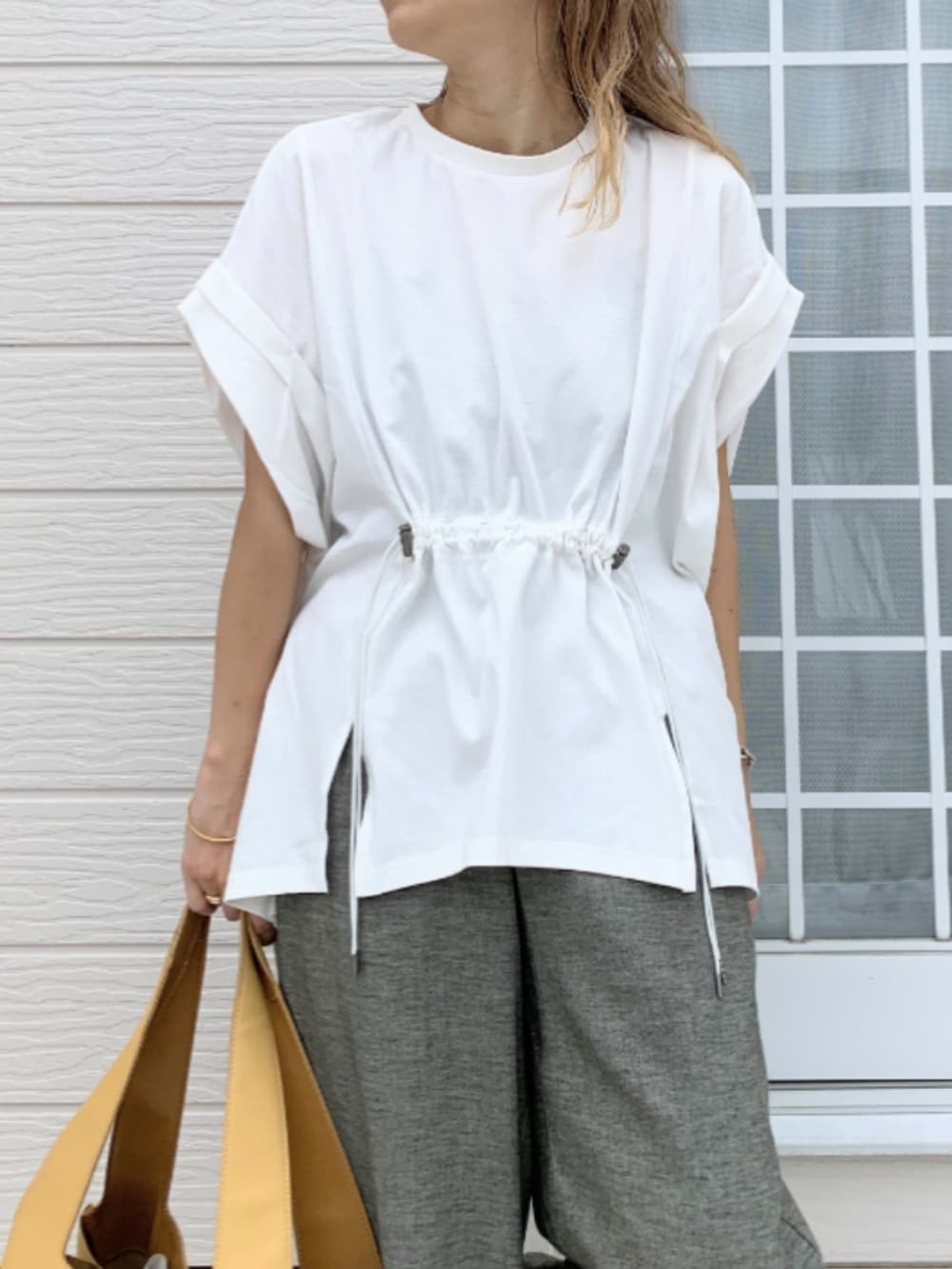 ブラック系のその他パンツ、ホワイト系のTシャツ/カットソー、イエロー系のトートバッグを着用したレディースの夏コーディネートの3枚目の写真