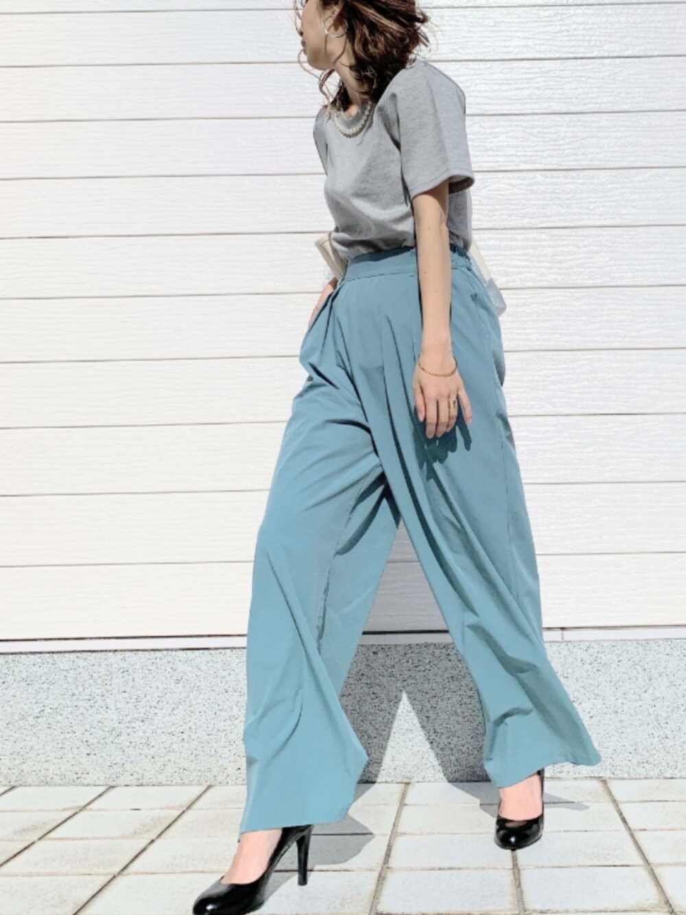 ブルー系のその他パンツ、シルバー系のハンドバッグ、グレー系のTシャツ/カットソーを着用したレディースの春コーディネートの2枚目の写真