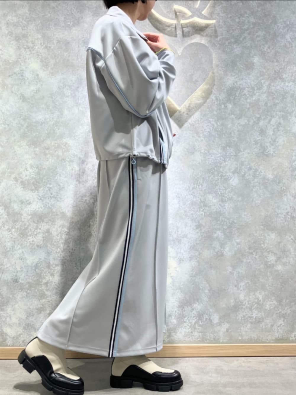 ホワイト系のブーツ、グレー系のその他アウター、グレー系のスカートを着用したレディースの春コーディネートの2枚目の写真